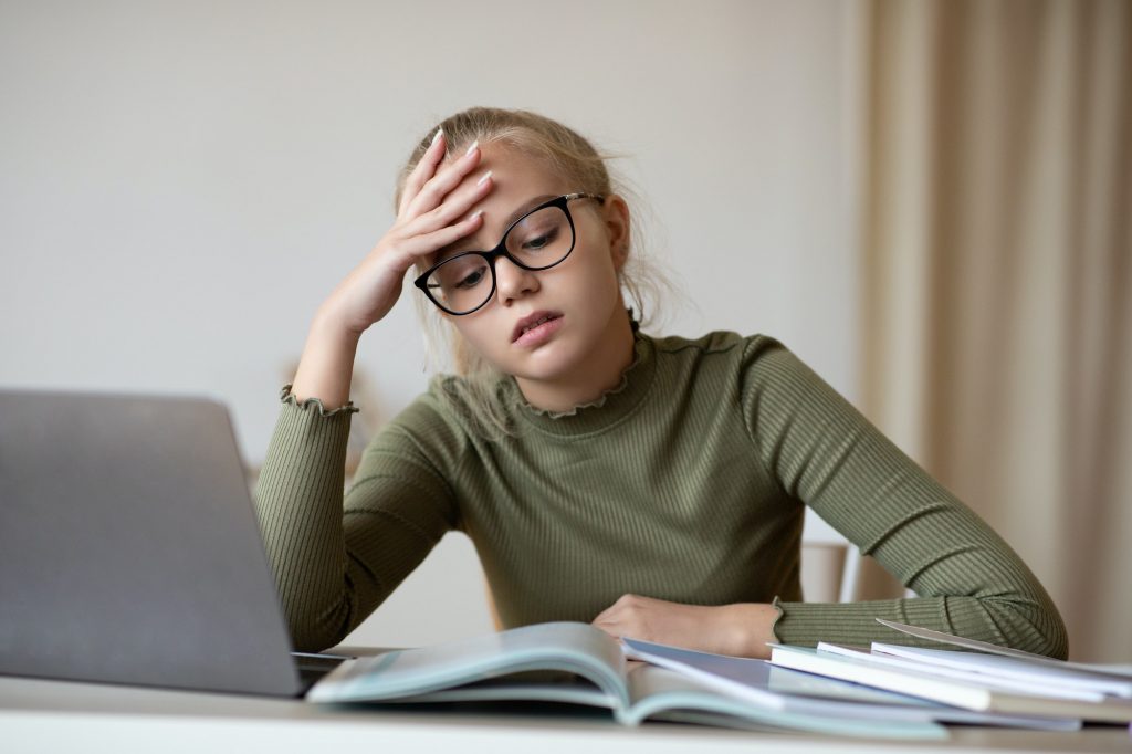 Teenager blonde girl having difficulties with studying